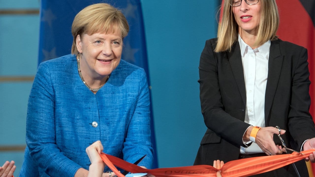 Bundeskanzlerin Angela Merkel (CDU, l) und Claudia Perren, Direktorin der Stiftung Bauhaus Dessau, zerschneiden zur Eröffnung des Bauhaus Museums Dessau ein rotes Band.