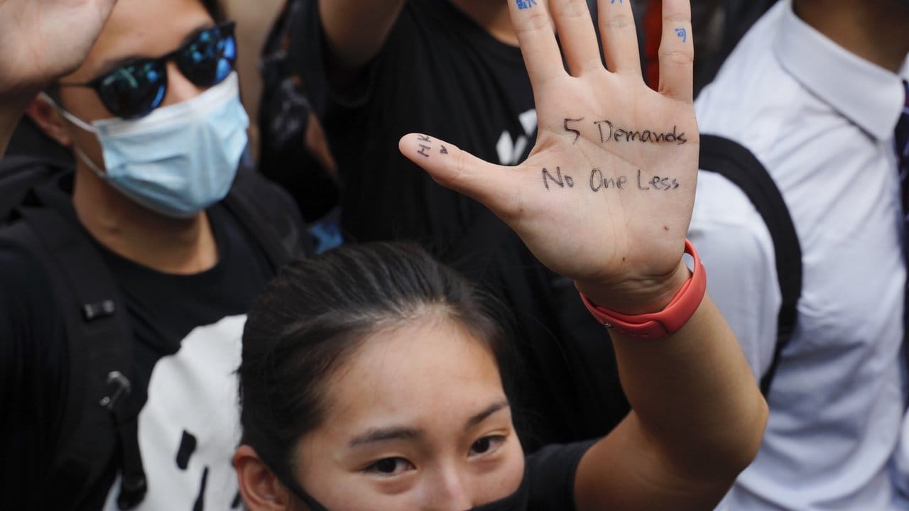 "Fünf Forderungen, nicht eine weniger" steht auf der Handfläche einer Demonstrantin.