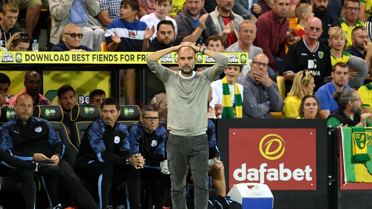 Trainer Guardiola steht an der Seitenlinie und fasst sich aufgrund der Niederlage gegen Norwich City an den Kopf.