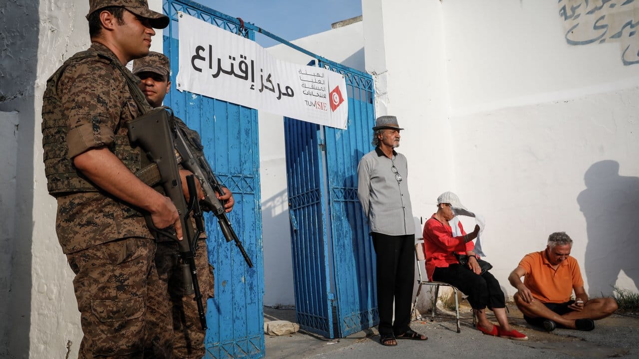 Soldaten stehen vor einem Wahllokal Wache.