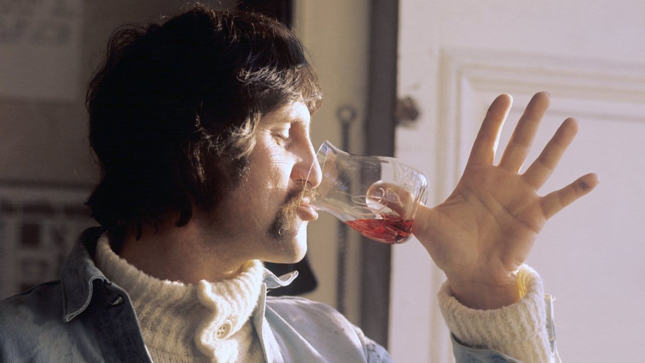 Luigi Colani mit einem von ihm gestalteten Weinglas, das statt Stiel eine Vertiefung im Boden hat.