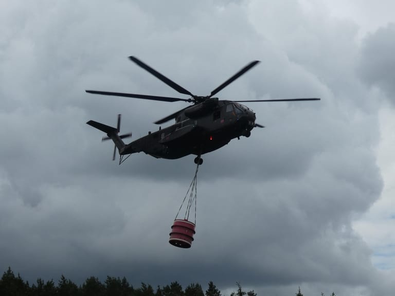 Einsatz bei einem Waldbrand im Juli 2019: Ein Hubschrauber fliegt zu Löscharbeiten in den Wald.