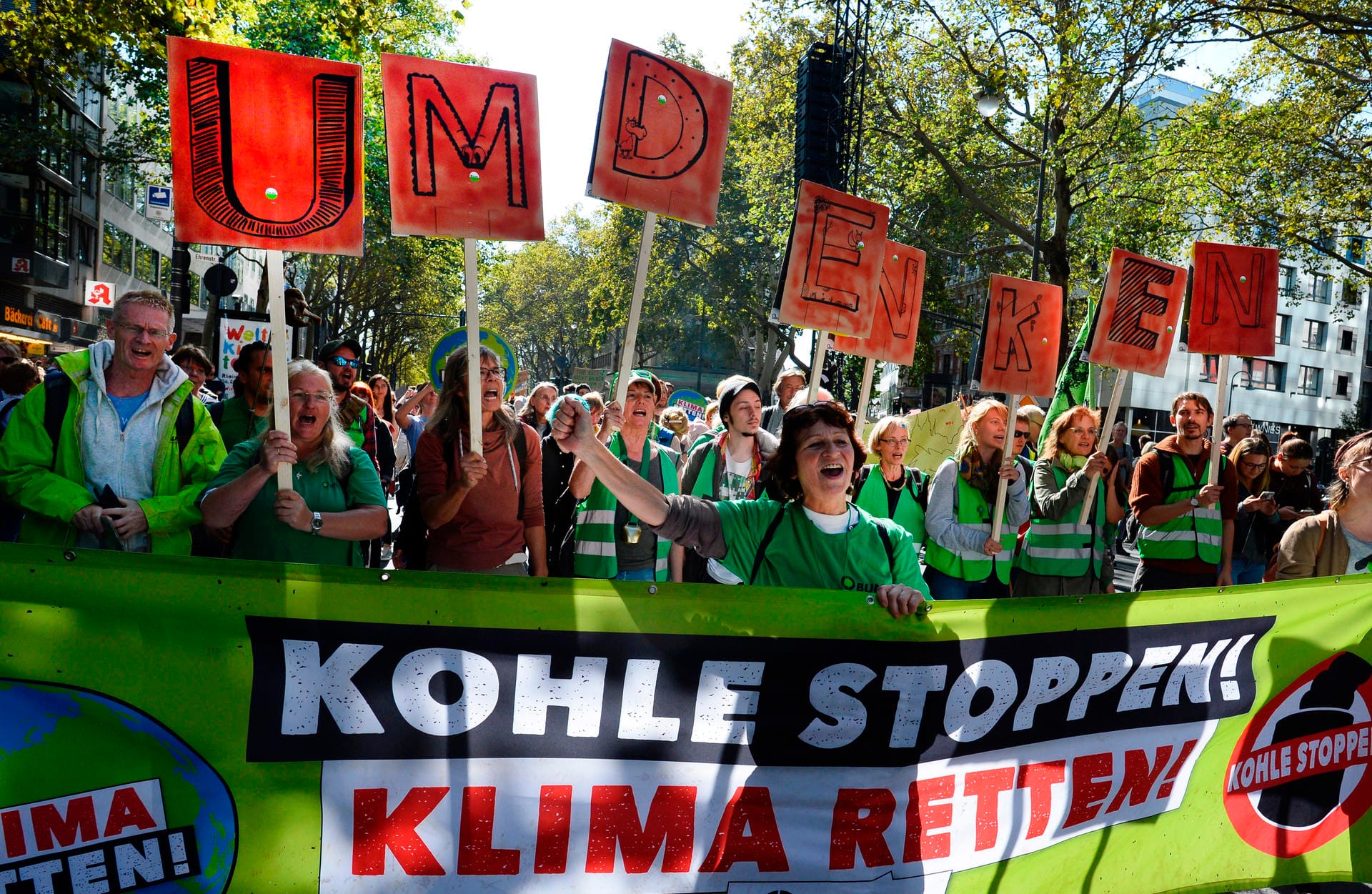 Jugendliche demonstrieren in Köln mit einem Banner "Kohle stoppen Klima retten!".