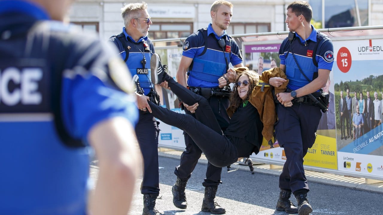 Abgasfrei zum Polizeiwagen: Eine Demonstrantin wird in Lausanne weggetragen.