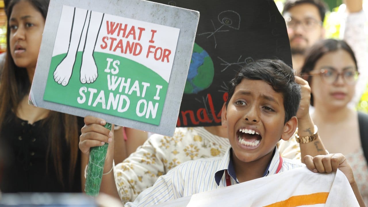 Ein junger Teilnehmer einer Demonstration in Indiens Hauptstadt Neu-Delhi hält ein Protestschild mit der Aufschrift: "What I stand for is what I stand on" (Wofür ich stehe ist worauf ich stehe).