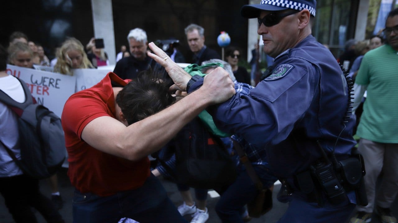 In Sydney kommt es zu einer Rangelei zwischen einem Demonstranten und einem Polizisten.