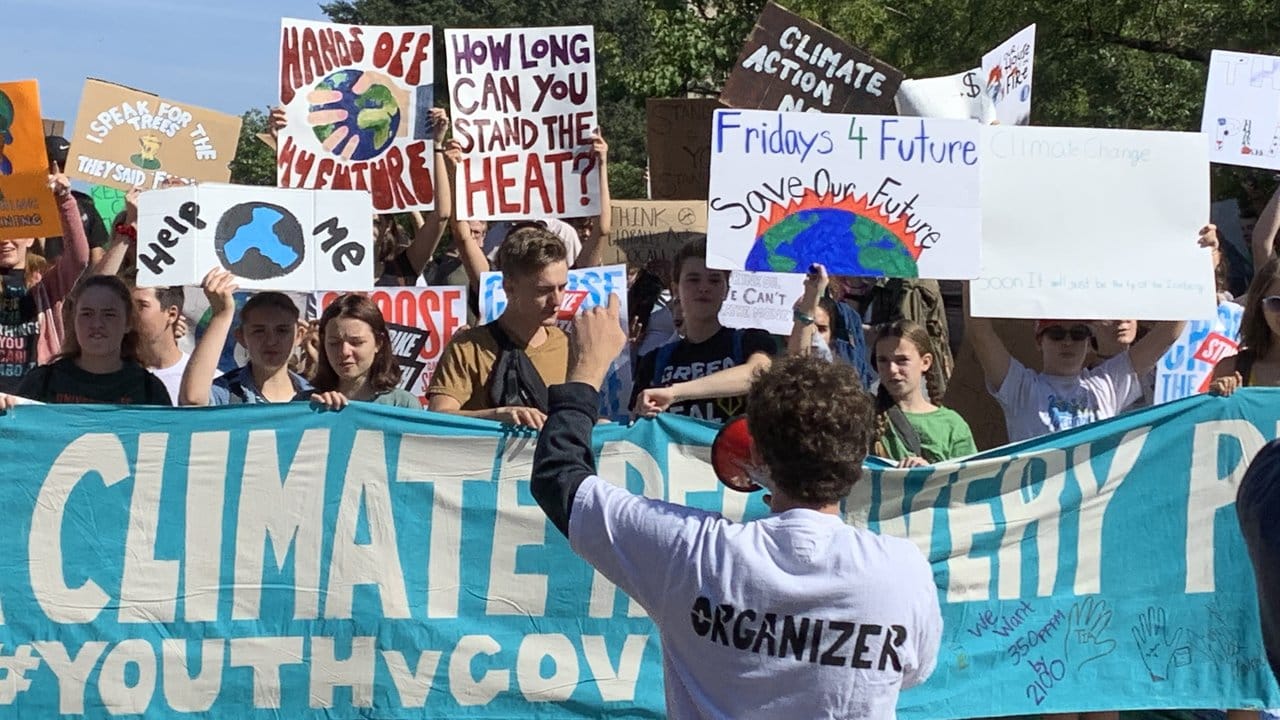 Demonstranten nehmen mit Protestplakaten und einem Banner mit der Aufschrift "We Demand a Climate Recovery Plan" an einem Protestmarsch in Washington teil.
