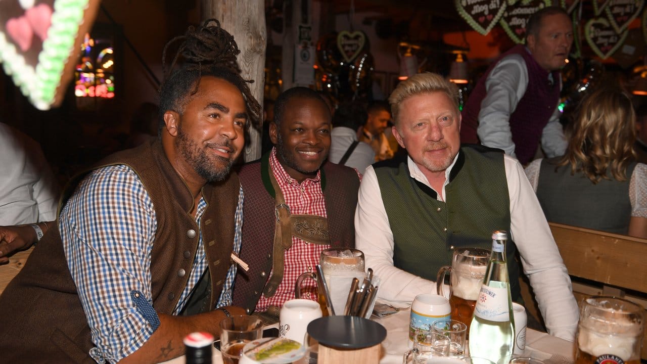 Der ehemalige Fußballer Patrick Owomoyela (l-r), Raphael de Souza und Boris Becker feiern beim Almauftrieb im Käferzelt.