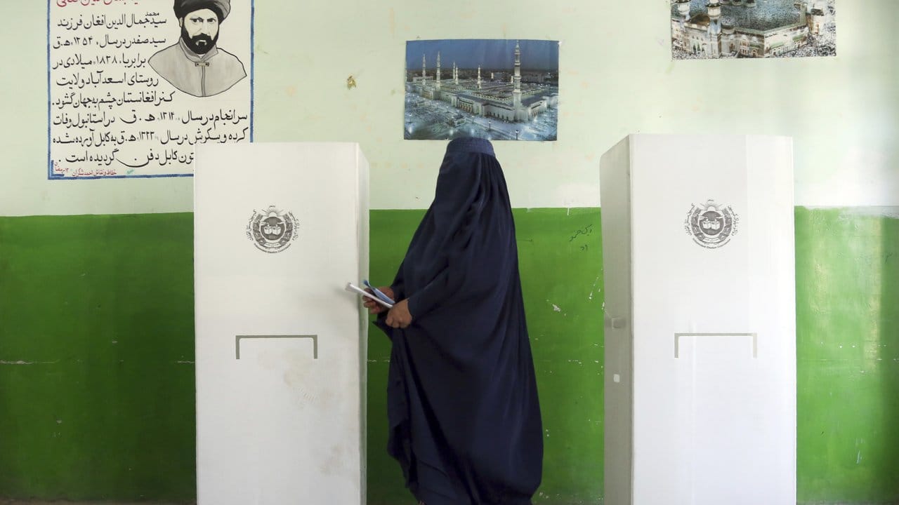 Eine afghanische Wählerin verlässt eine Wahlkabine.