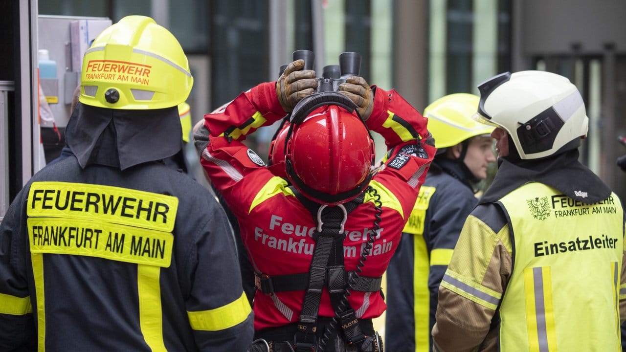 Mit dem Fernglas verfolgen Höhenretter der Frankfurter Feuerwehr vom Boden aus den Abstieg des Extremkletterers. Mit dem Fernglas verfolgen Höhenretter der Frankfurter Feuerwehr vom Boden aus den Abstieg des Extremkletterers.