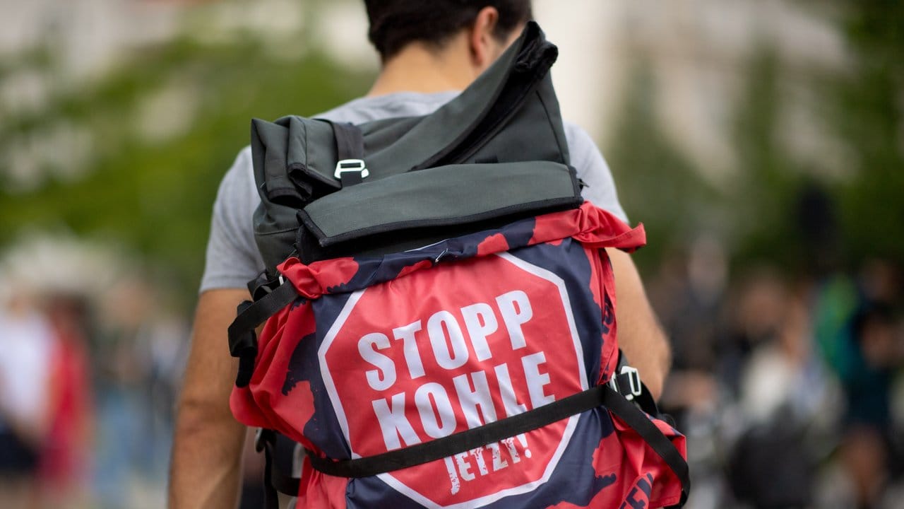 Ein Teilnehmer einer "Fridays for Future"-Klimademonstration hat an seinem Rucksack ein Transparent mit der Aufschrift "Stopp Kohle jetzt!" befestigt. Ein Teilnehmer einer "Fridays for Future"-Klimademonstration hat an seinem Rucksack ein Transparent mit der Aufschrift "Stopp Kohle jetzt!" befestigt.