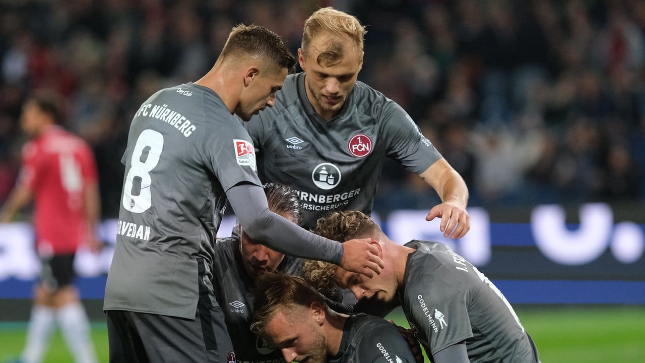 Nürnbergs Spieler feiern Torschütze Hanno Behrens (unten, M) nach seinem Treffer zum 2:0 gegen Hannover 96.