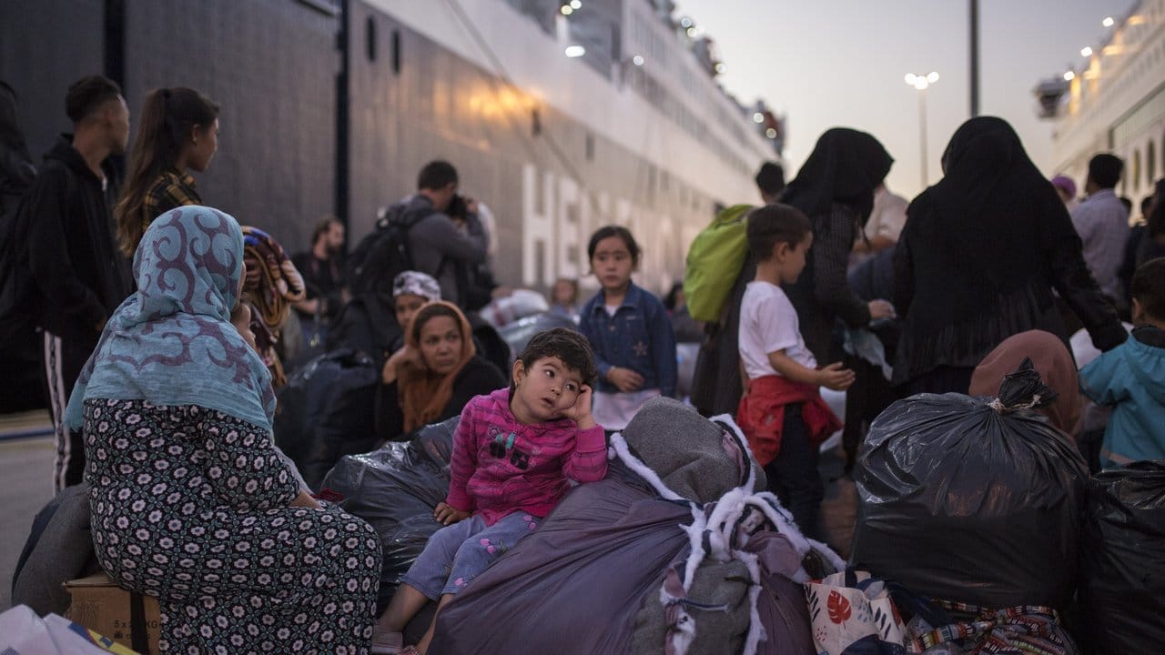 Flüchtlinge und Migranten verlassen im Hafen von Piräus eine Fähre.