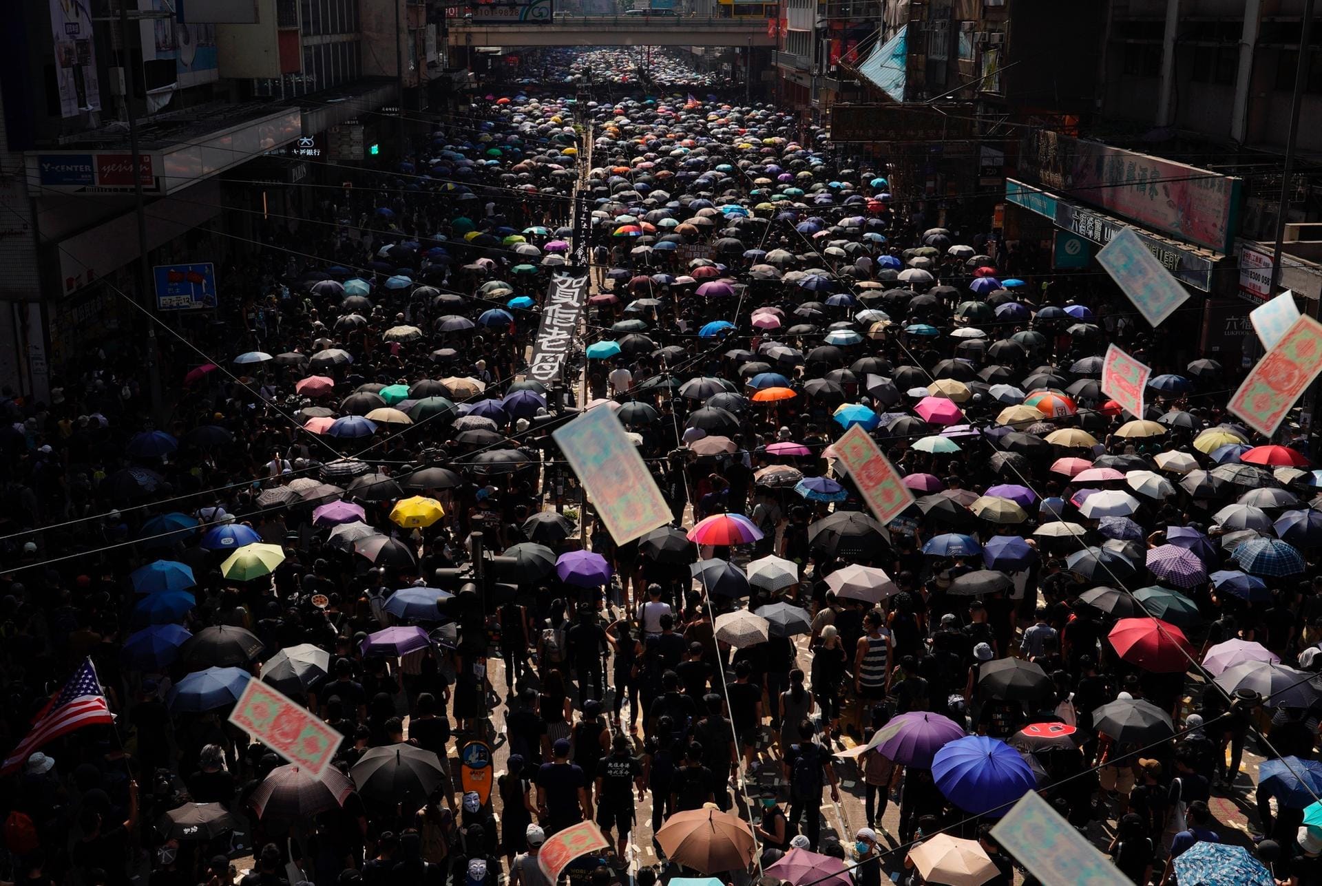 Zehntausende Demonstranten marschieren durch Hongkong, zumeist schwarz gekleidet und mit Regenschirmen.