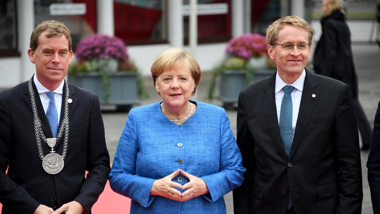 Ulf Kämpfer, Kieler Oberbürgermeister, Bundeskanzlerin Merkel und Daniel Günther, Ministerpräsident von Schleswig-Holstein, stehen im Rahmen der zentralen Feier zum Tag der Deutschen Einheit zusammen.