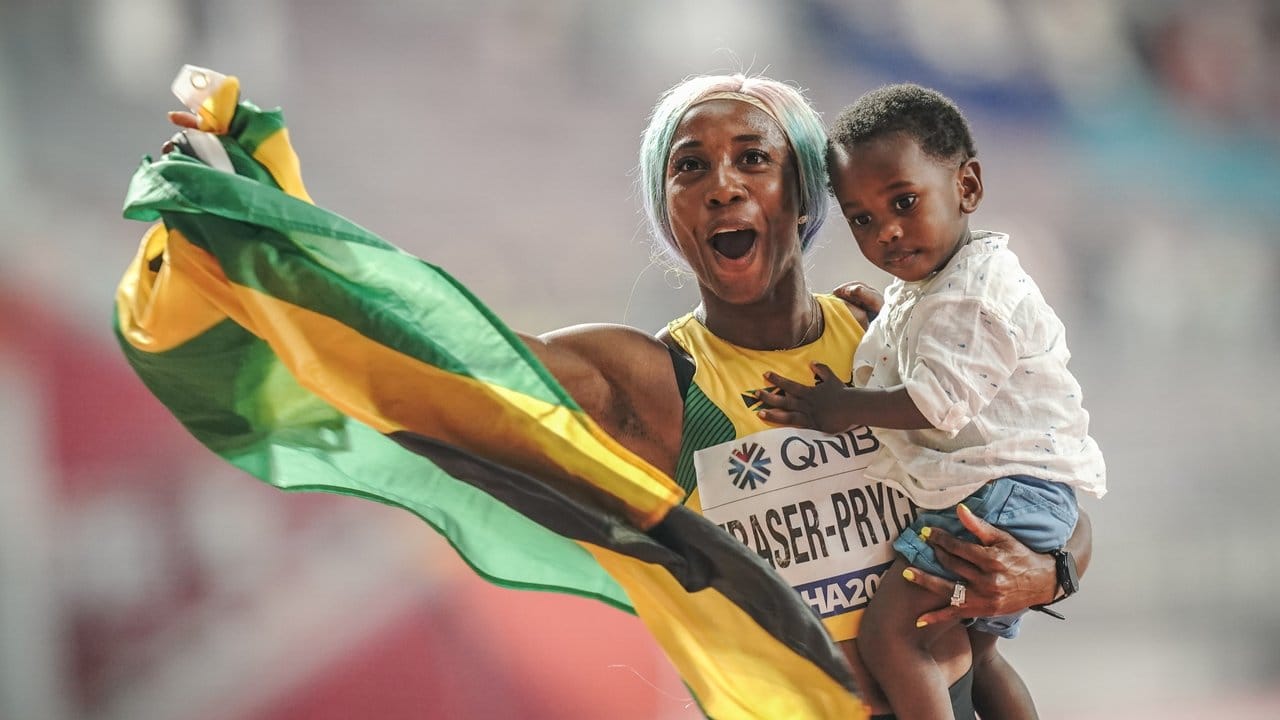 Sprint-Weltmeisterin Shelly-Ann Fraser-Pryce feiert ihren Erfolg mit ihrem Sohn Zyon auf dem Arm.