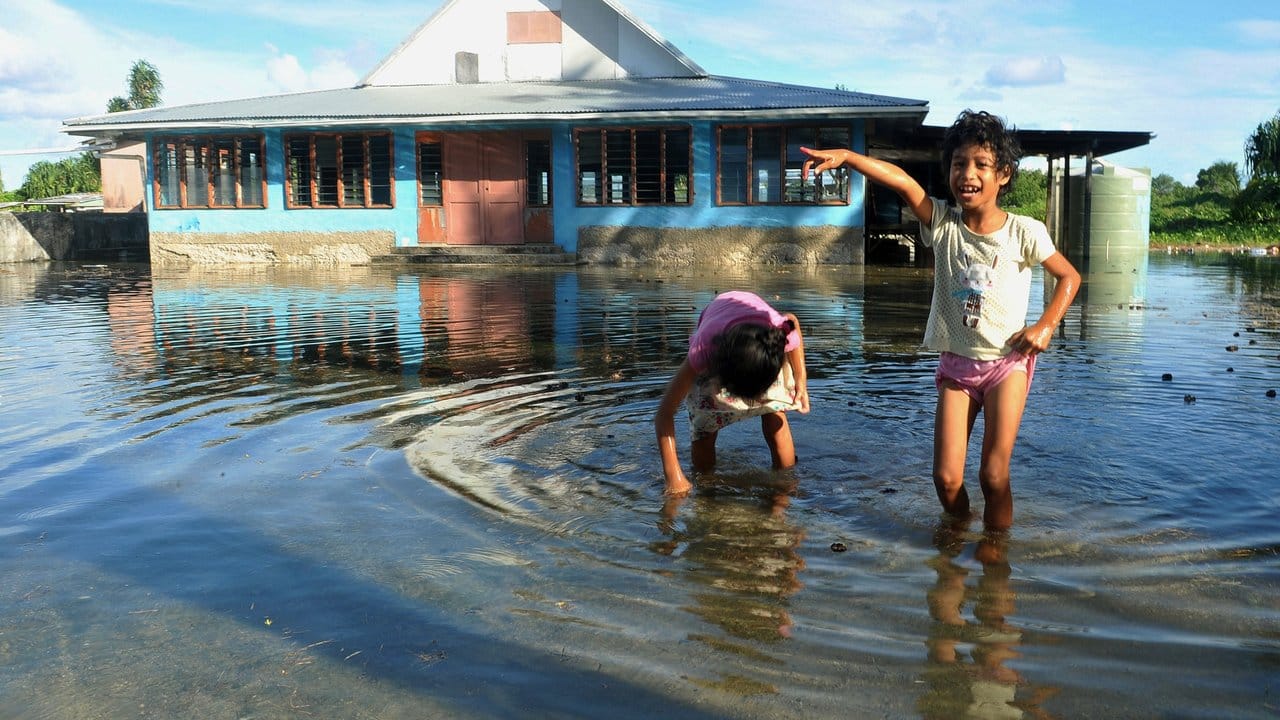 Kinder spielen auf einem vom Meerwasser überfluteten Platz in Funafuti, der Hauptstadt des pazifischen Inselstaats Tuvalu.