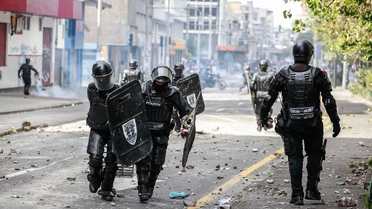Sicherheitskräfte in einer mit Steinen und Scherben bedeckten Straße der Hauptstadt.