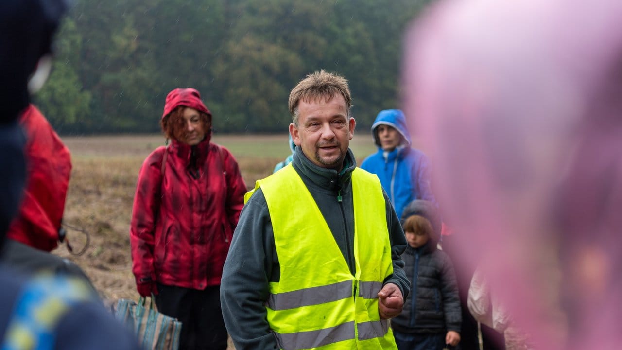 Ein Bio-Landwirt spricht zu den Teilnehmern der Aktion gegen Lebensmittelverschwendung, die vom Verein Restlos Glücklich e. Ein Bio-Landwirt spricht zu den Teilnehmern der Aktion gegen Lebensmittelverschwendung, die vom Verein Restlos Glücklich e.