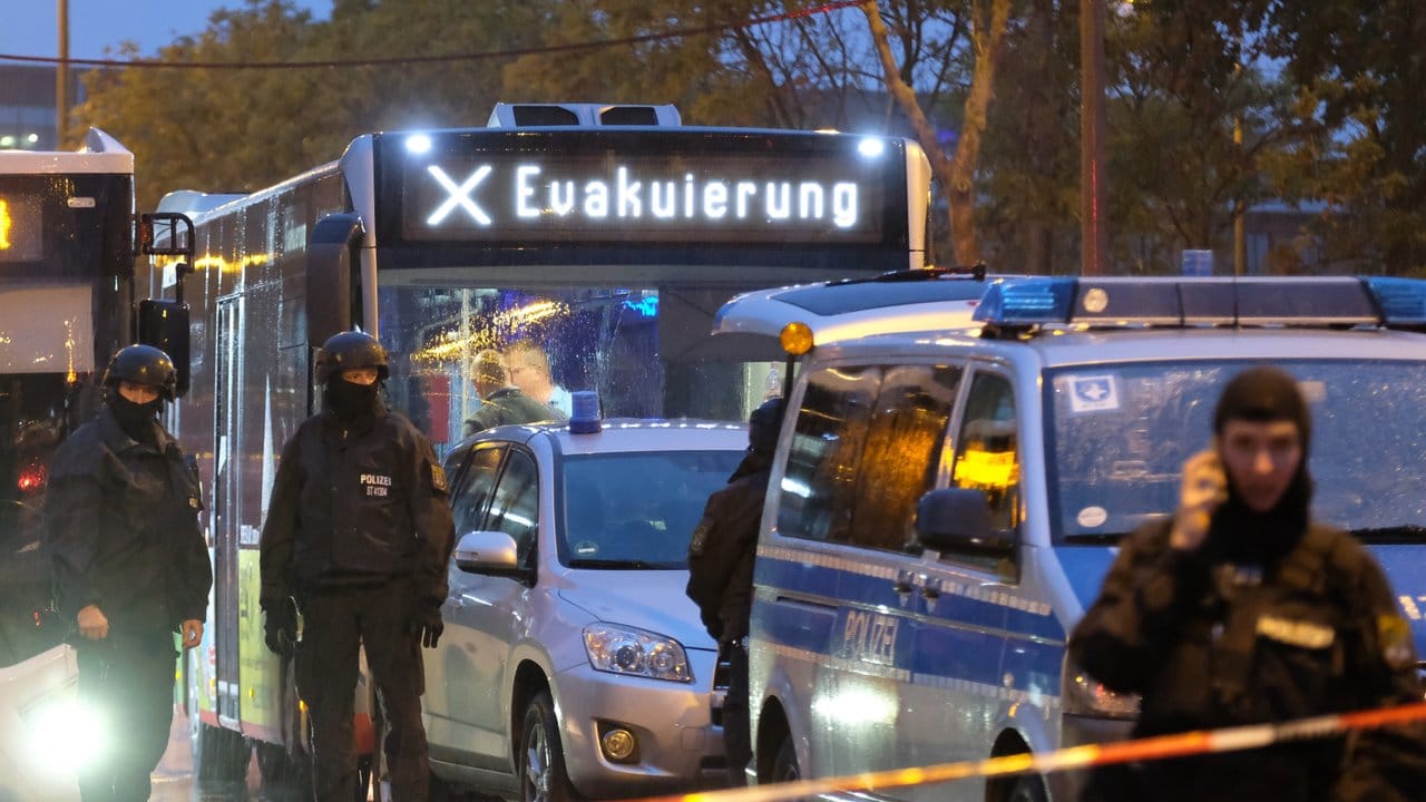 Ein Bus mit der Aufschrift "Evakuierung" wird von Polizei eskortiert . Ein Bus mit der Aufschrift "Evakuierung" wird von Polizei eskortiert .