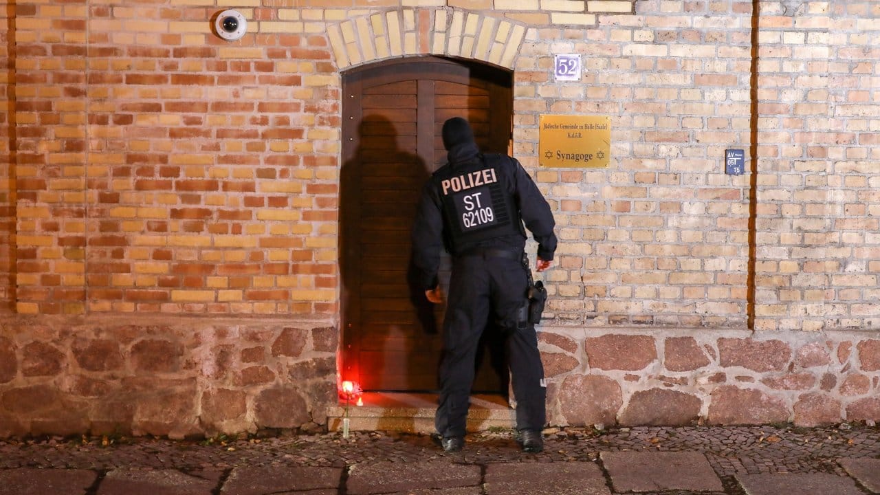 Ein Polizist geht zum Eingang der Synagoge in Halle.