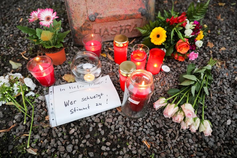 Kerzen, Blumen und ein Zettel mit der Aufschrift "In tiefer Trauer. Wer schweigt, stimmt zu!" liegen vor dem Dönerimbiss, in dem ein Mensch starb.