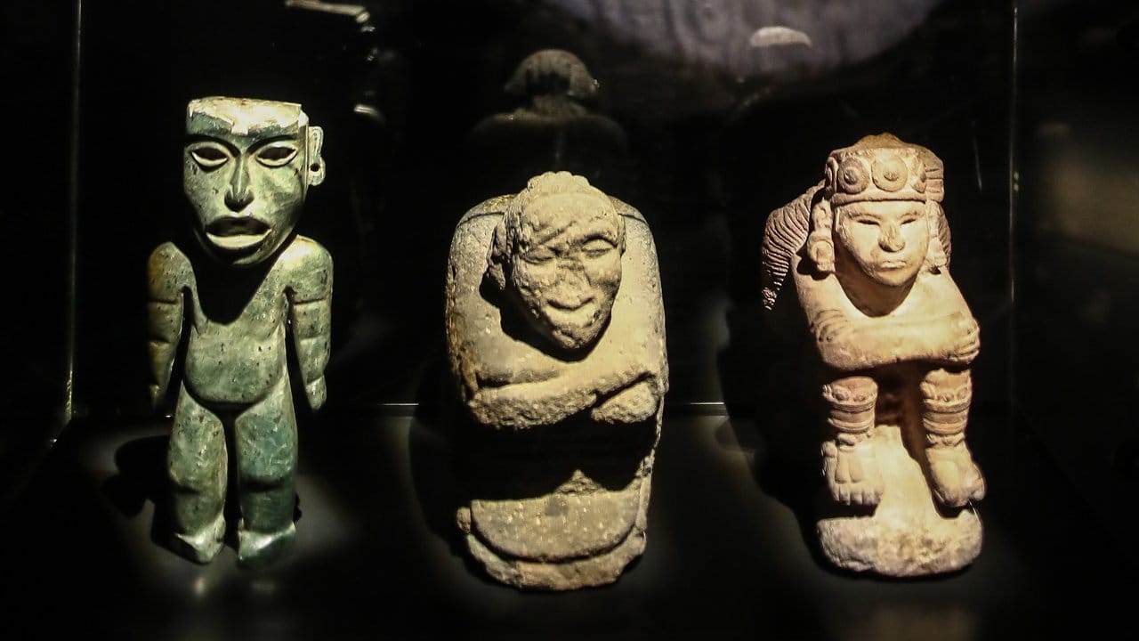 Eine Grünsteinfigur mit Kalenderzeichen (l-r), der bucklige Gott Nanahuatzin und der Sonnengott Tonatiuh. Eine Grünsteinfigur mit Kalenderzeichen (l-r), der bucklige Gott Nanahuatzin und der Sonnengott Tonatiuh.