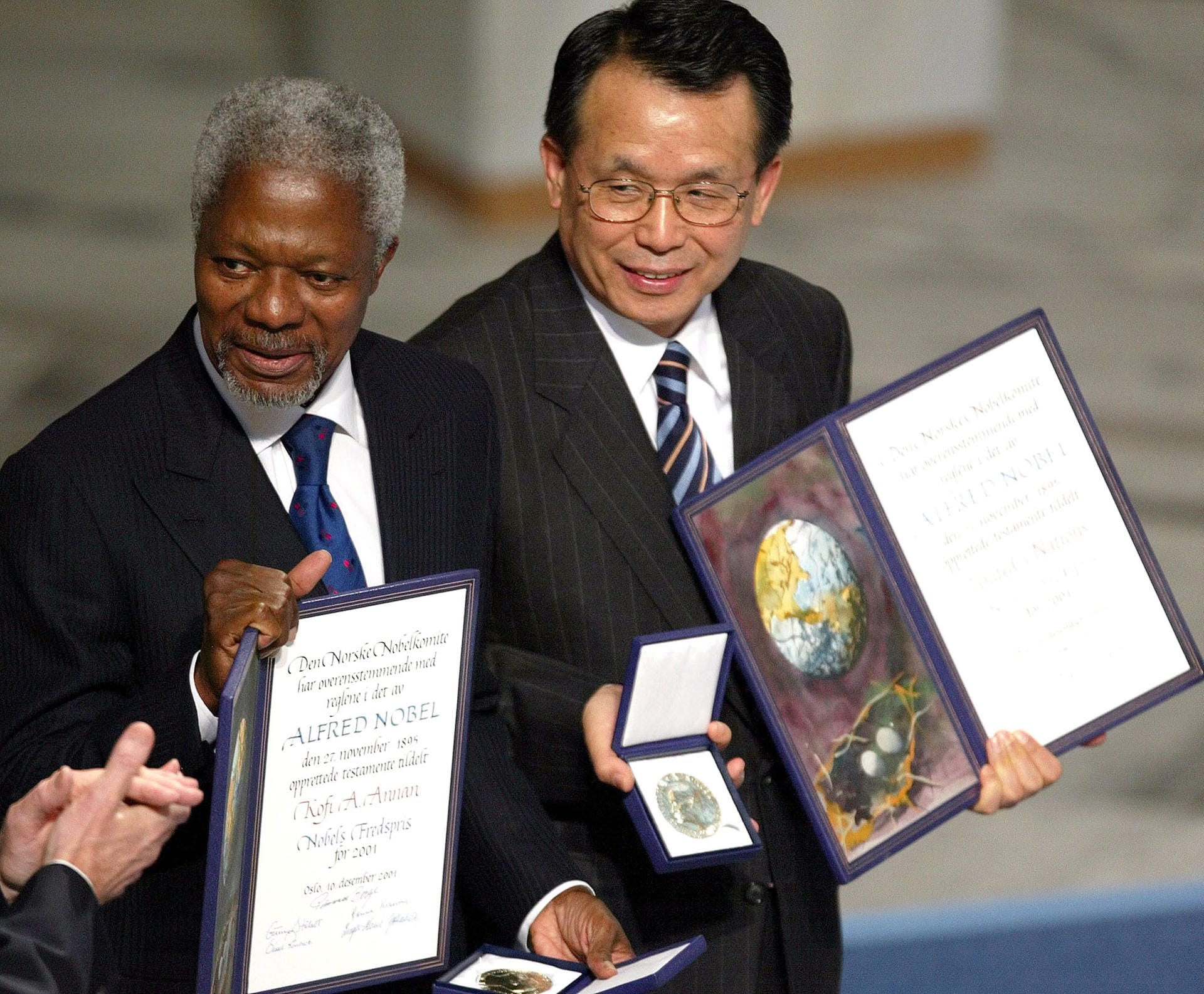 2001 teilten sich Kofi Annan, ein ghanaischer Diplomat (links, † 2018) und die Vereinten Nationen den Friedensnobelpreis. Sie erhielten die Auszeichnung für ihren Einsatz für eine besser organisierte und friedlichere Welt. Der koreanische Außenminister und Präsident der Generalversammlung (r), Han Seung Soo, hält hier den Preis in der Hand.