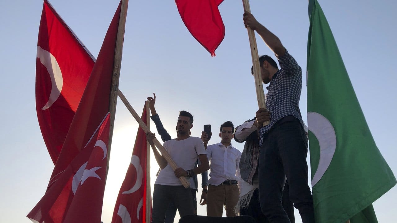 Männer schwenken in Akçakale Nationalflaggen und feiern die Erfolge der türkischen Truppen.