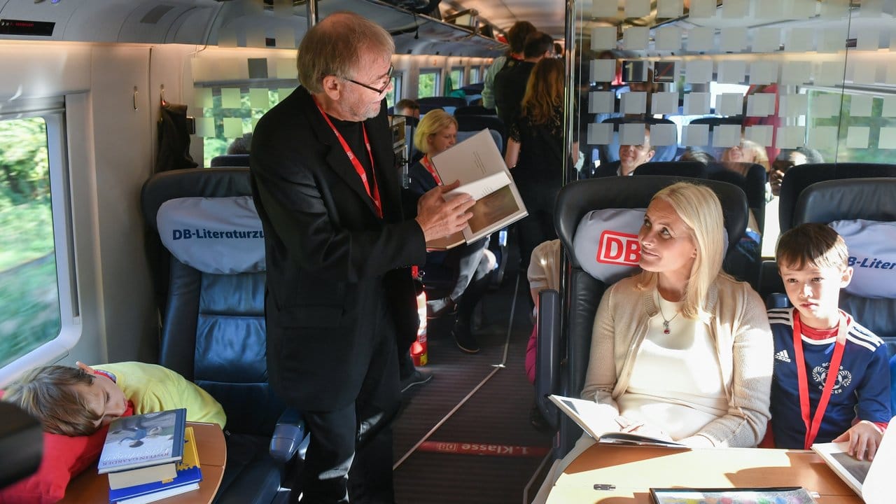 Kronprinzessin Mette-Marit und der Buchautor Jostein Gaarder (l) lesen mit Kindern im Literaturzug.