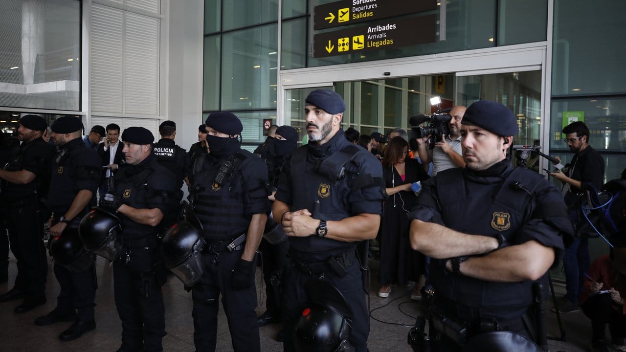 Polizisten schützen einen Eingang zum Flughafen El Prat in Barcelona, um eine Blockade durch Demonstranten zu verhindern.