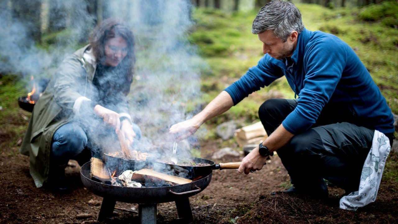 Mitten im Wald des Landguts Asa Herrgård bereitet Chefkoch Pontus Sjöholm auf zwei Feuerschalen für Gäste ein 3-Gänge-Menü zu.