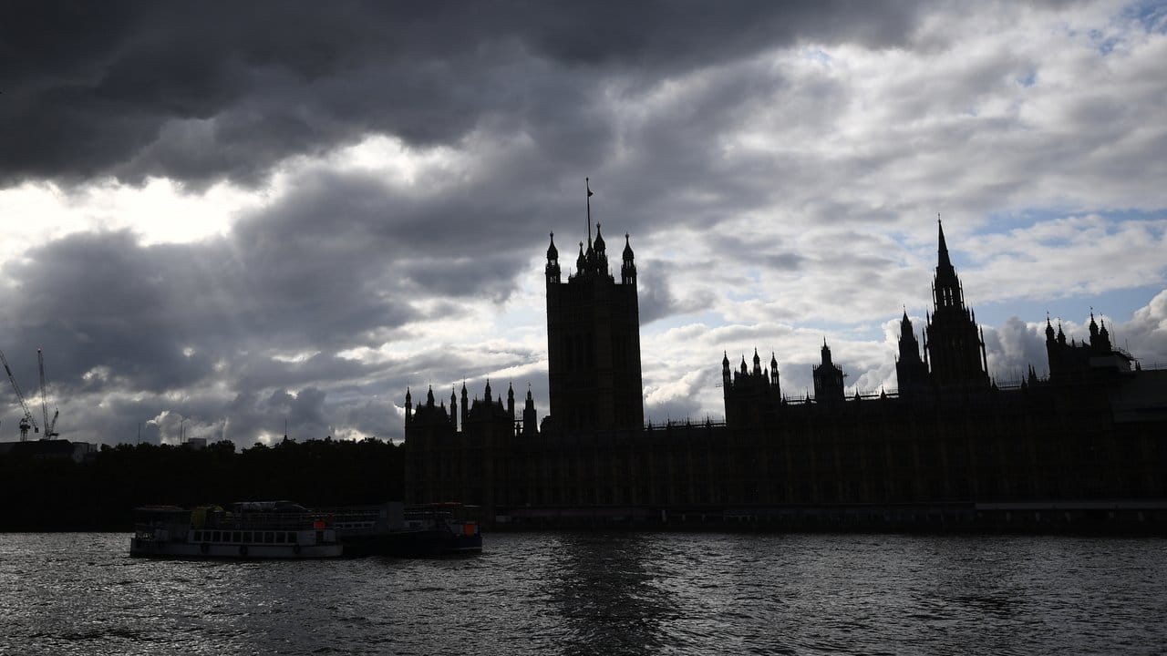 Der Palast von Westminster liegt im Schatten, während dunkle Wolken über dem Parlament aufziehen.