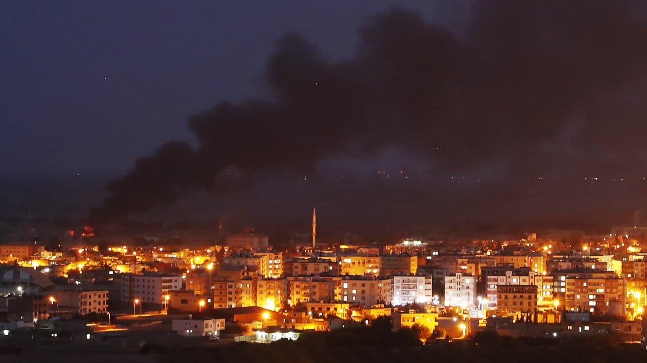 Auf dem von der türkischen Seite der Grenze aufgenommenen Foto ist Rauch zu sehen, der über der syrischen Stadt Ras al-Ain aufsteigt. Auf dem von der türkischen Seite der Grenze aufgenommenen Foto ist Rauch zu sehen, der über der syrischen Stadt Ras al-Ain aufsteigt.