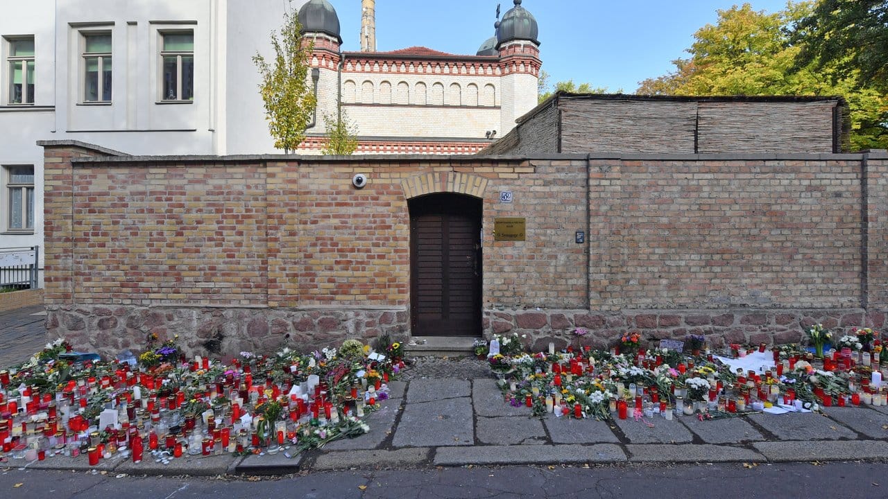 Blumen und Kerzen erinnern an der Synagogentür an den Terroranschlag.