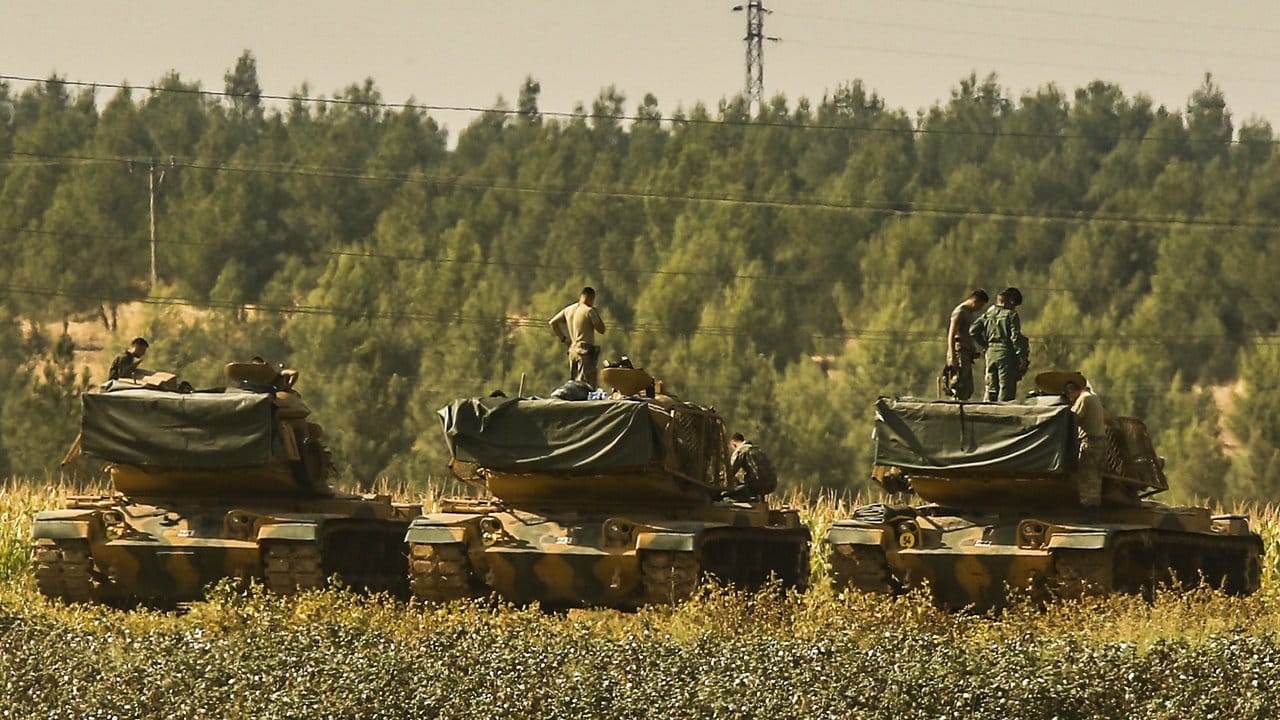 Türkische Soldaten stehen nahe der syrischen Grenze auf Panzern. Türkische Soldaten stehen nahe der syrischen Grenze auf Panzern.