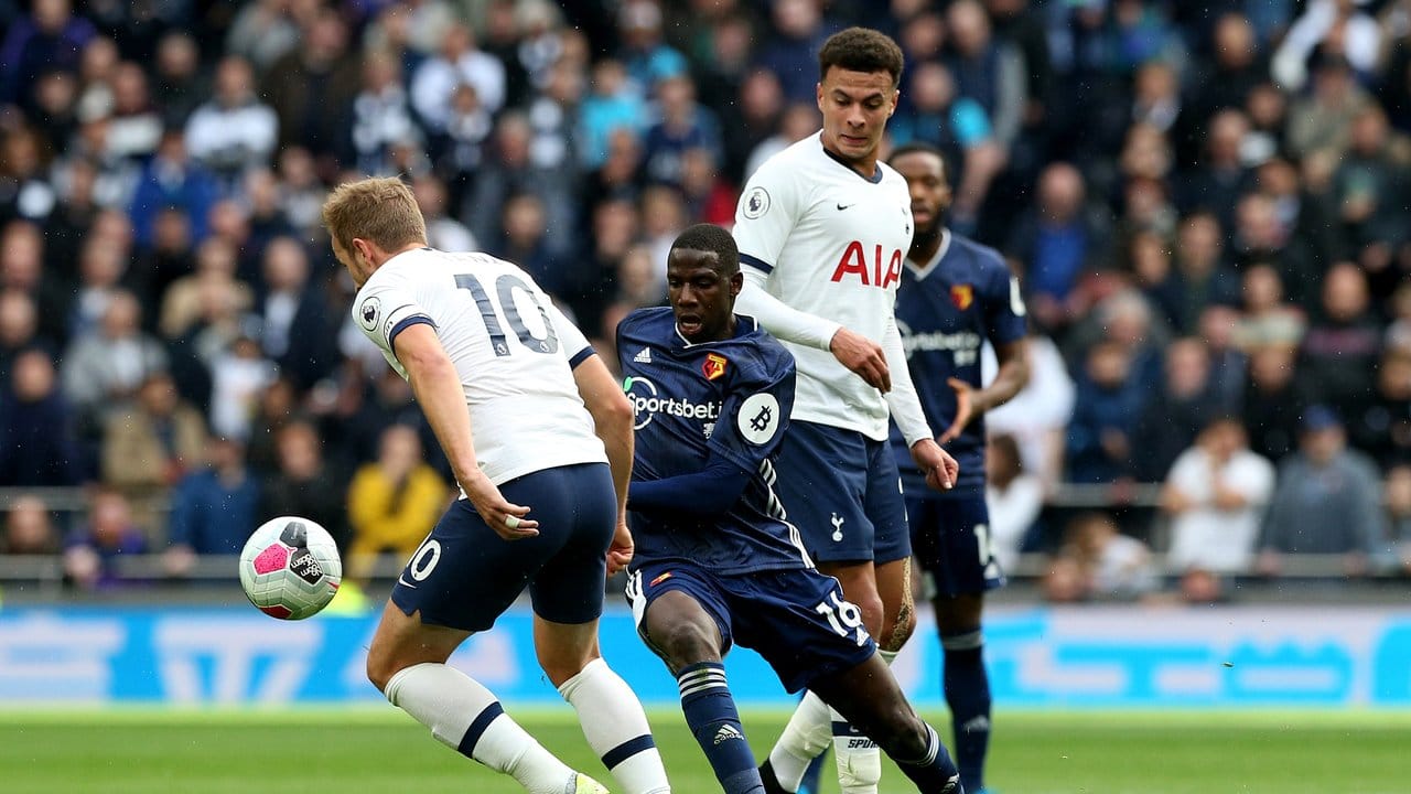 Watfords Abdoulaye Doucoure (M) kämpft mit Tottenhams Harry Kane (l) und Dele Alli (r) um den Ball.