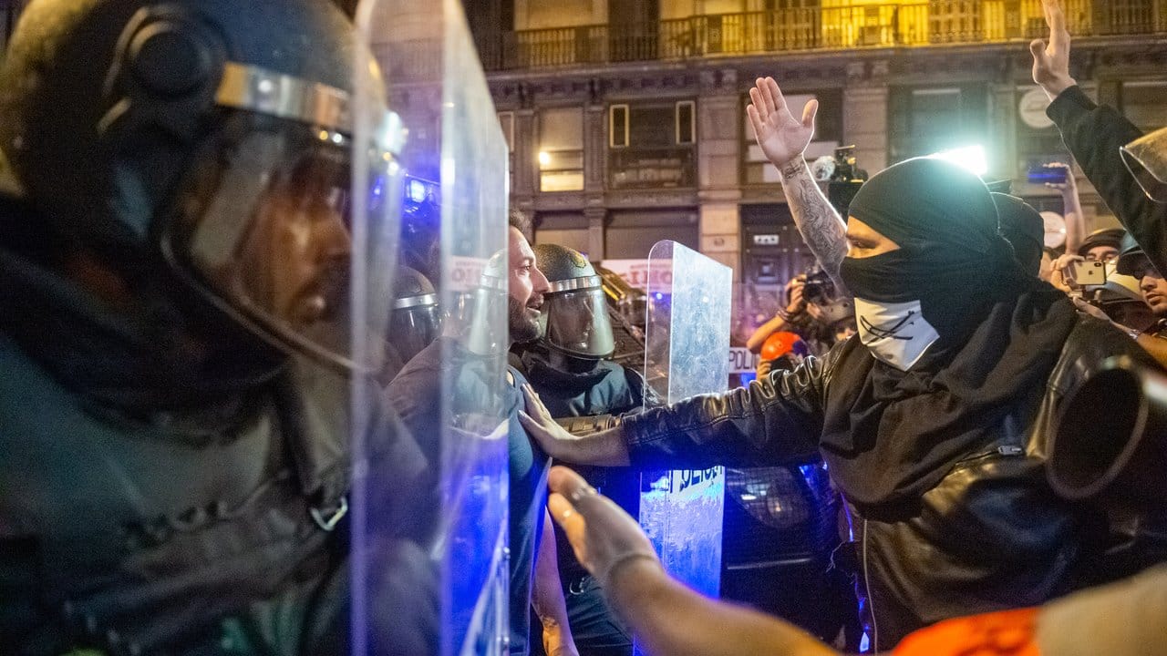 In der Innenstadt von Barcelona stehen sich Demonstranten und Polizisten gegenüber.