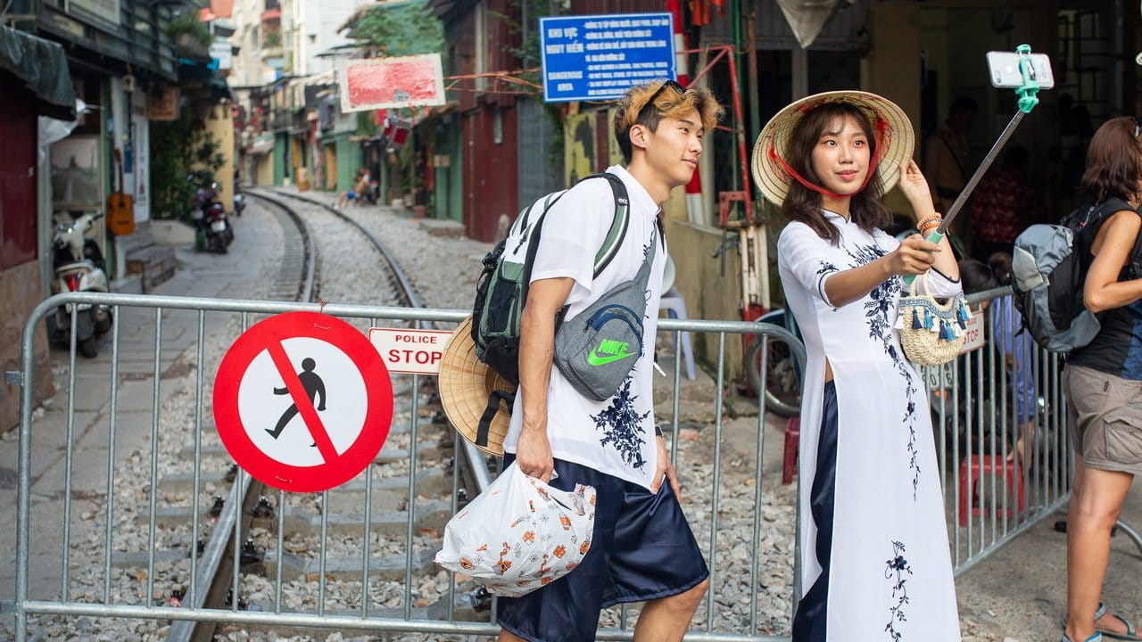 Ein Paar macht ein Selfie an der Absperrung zur "Train Street": Touristen müssen sich in Hanoi von der berühmt gewordenen Sehenswürdigkeit verabschieden.