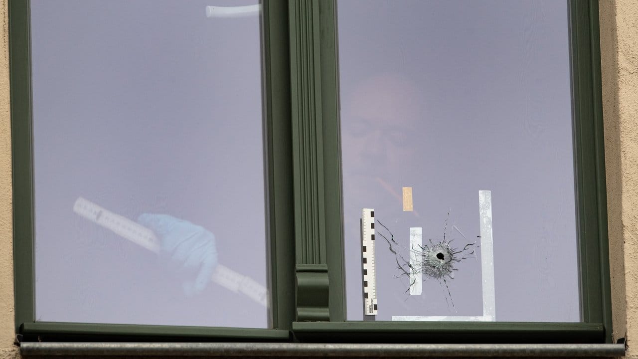 Mörderischer Antisemitismus: Ein Beamter der Spurensicherung untersucht ein Einschussloch in einem Fenster in einem Haus gegenüber der Synagoge von Halle/Saale.