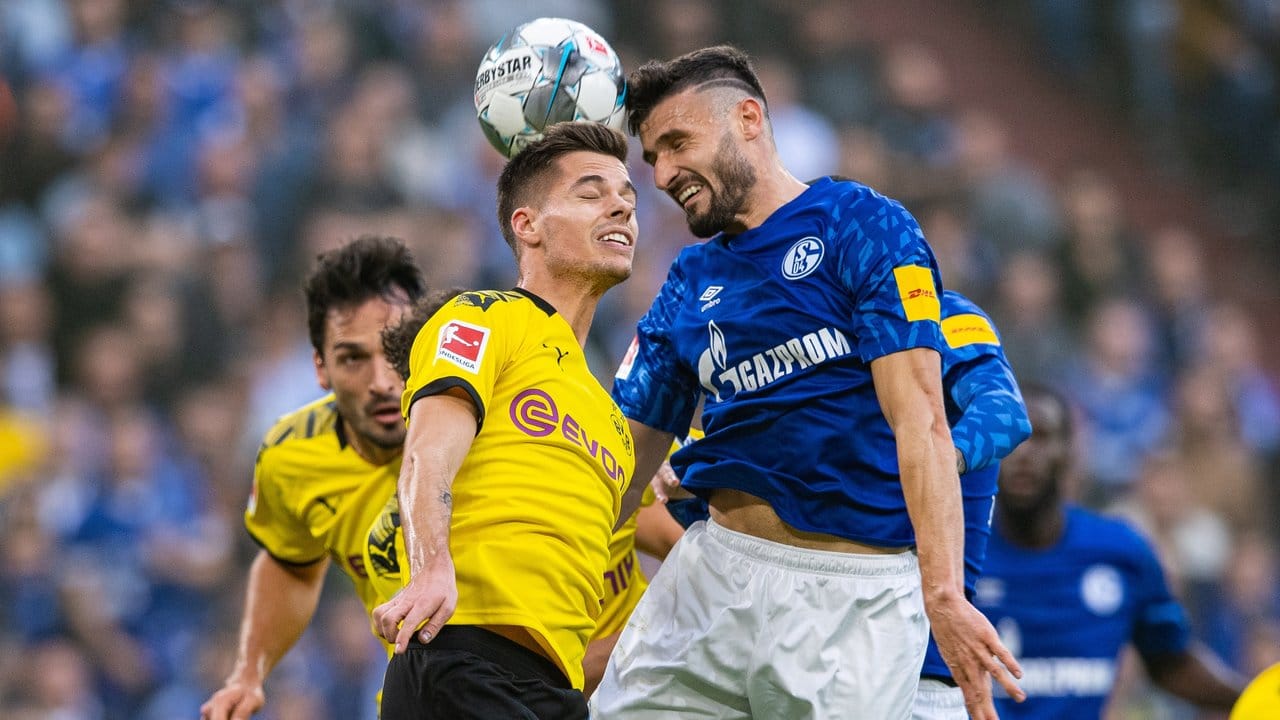 Dortmunds Julian Weigl (l) und Schalkes Daniel Caligiuri kämpfen im Kopfballduell um den Ball.