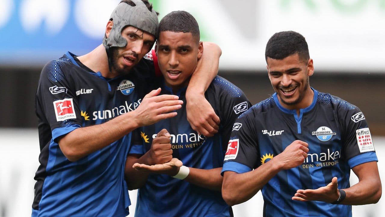 Paderborns Torschütze Abdelhamid Sabiri (M) feiert seinen Treffer zum 1:0 mit Klaus Gjasula (l) und Mohamed Dräger.