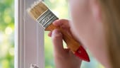 Fensterrahmen wird gestrichen: Abgenutzte Fensterrahmen können auch Mieter neu streichen. Den Austausch durch besser isolierte Fenster können sie aber nicht einfach verlangen.