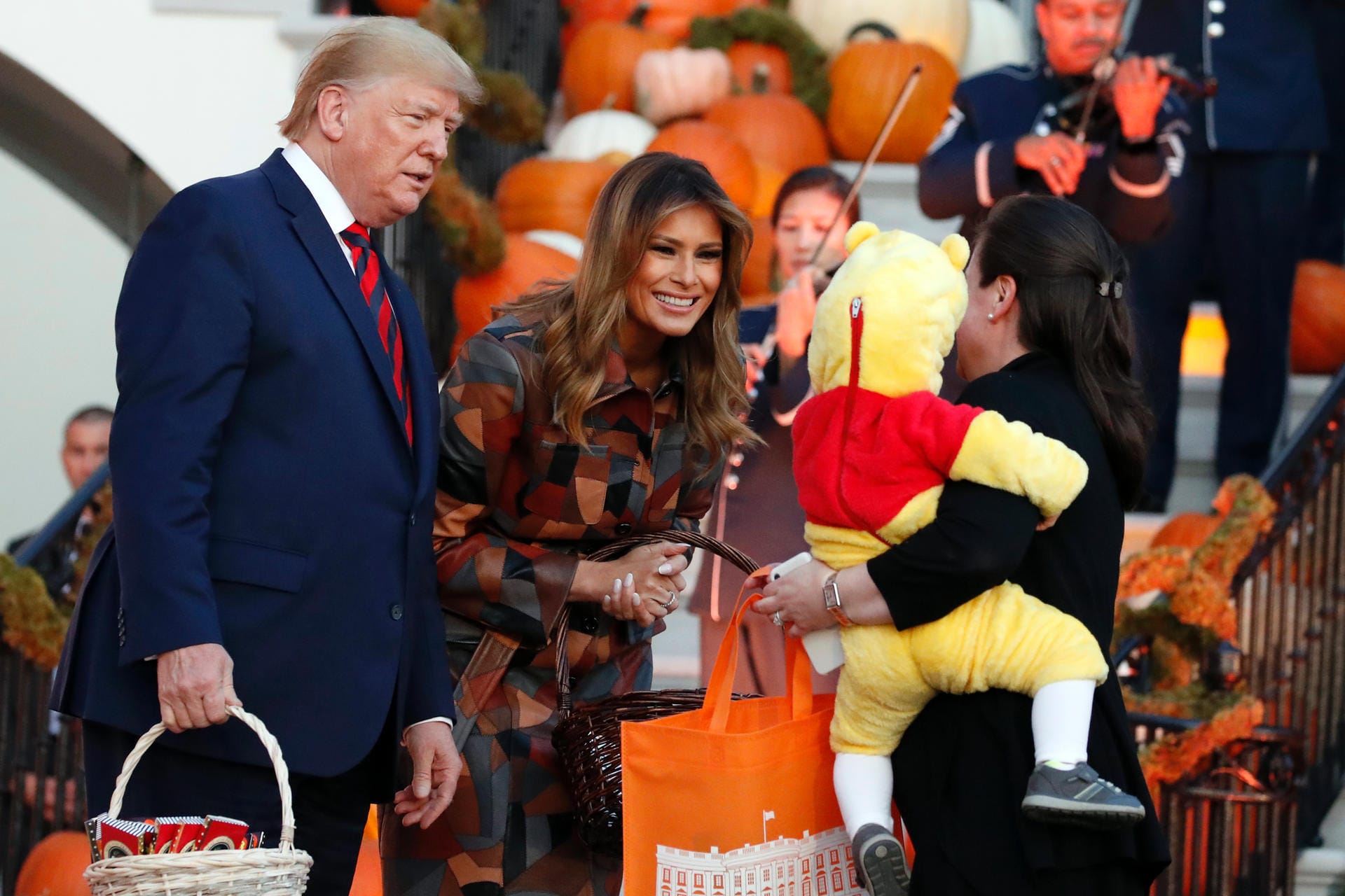 Eine Mutter kommt mit einem Kind im "Winnie Puuh"-Kostüm auf dem Arm zu den Trumps: Für die Präsidentenfamilie ist die Halloween-Feier im Weißen Haus vor allem ein PR-Event. Eine Mutter kommt mit einem Kind im "Winnie Puuh"-Kostüm auf dem Arm zu den Trumps: Für die Präsidentenfamilie ist die Halloween-Feier im Weißen Haus vor allem ein PR-Event.