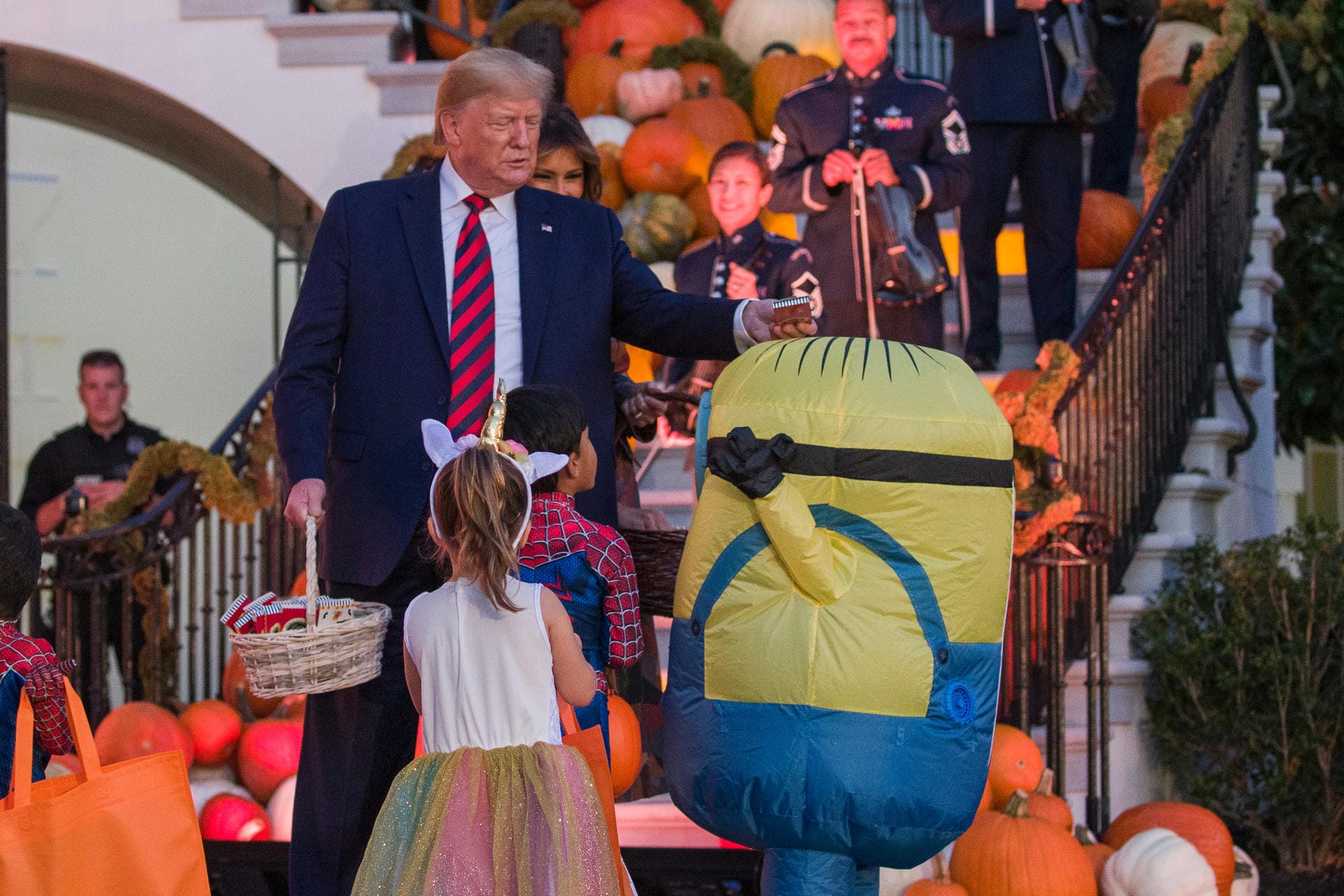 Trump legt einem Kind in einem "Minion"-Kostüm eine Süßigkeit auf den Kopf: Halloween wird in den USA traditionell sehr groß gefeiert. Trump legt einem Kind in einem "Minion"-Kostüm eine Süßigkeit auf den Kopf: Halloween wird in den USA traditionell sehr groß gefeiert.