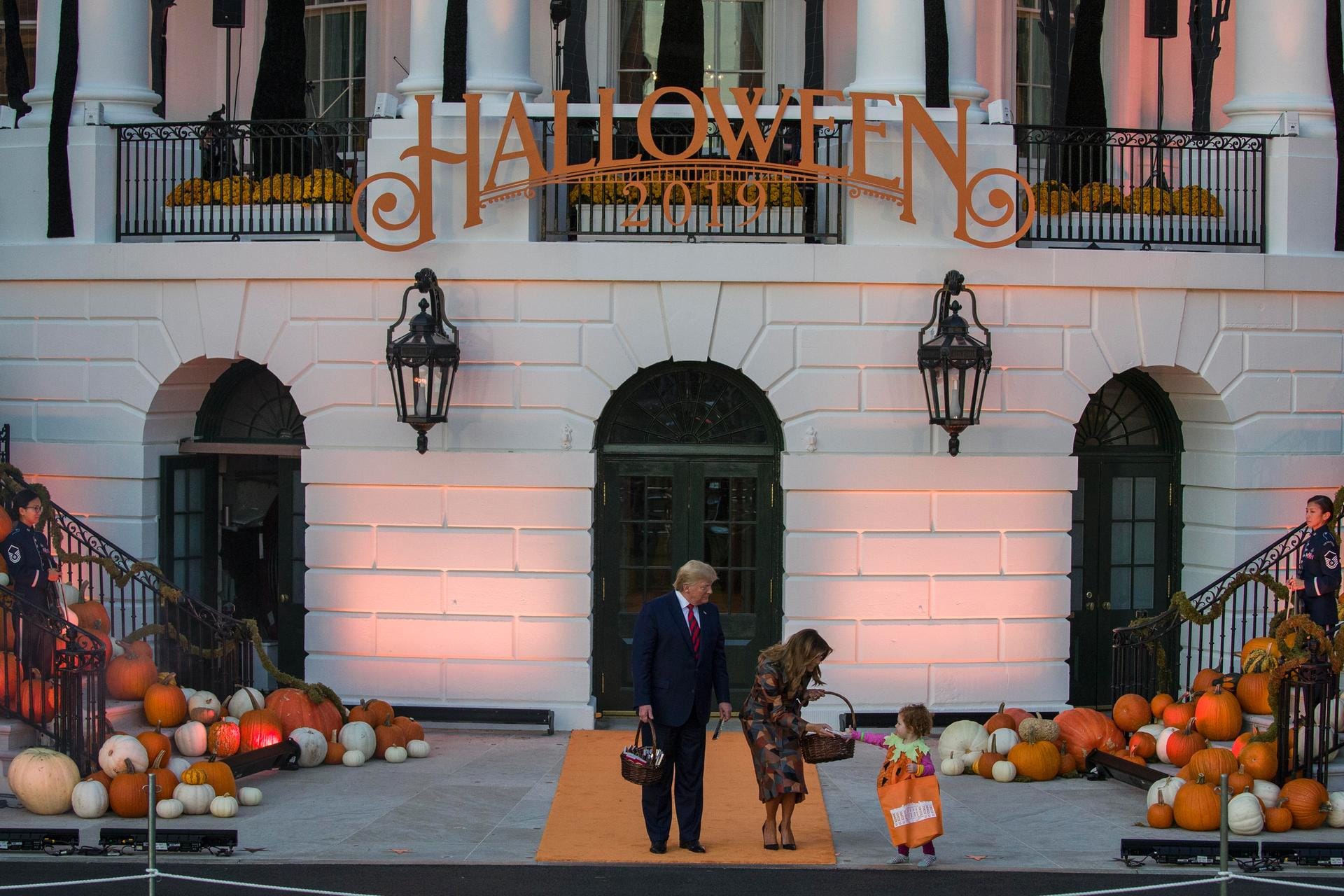 Donald und Melania Trump händigen einem Kleinkind Süßigkeiten aus: Für Halloween ist das Weiße Haus mit Kürbissen und gruseligen Motiven dekoriert worden. Donald und Melania Trump händigen einem Kleinkind Süßigkeiten aus: Für Halloween ist das Weiße Haus mit Kürbissen und gruseligen Motiven dekoriert worden.
