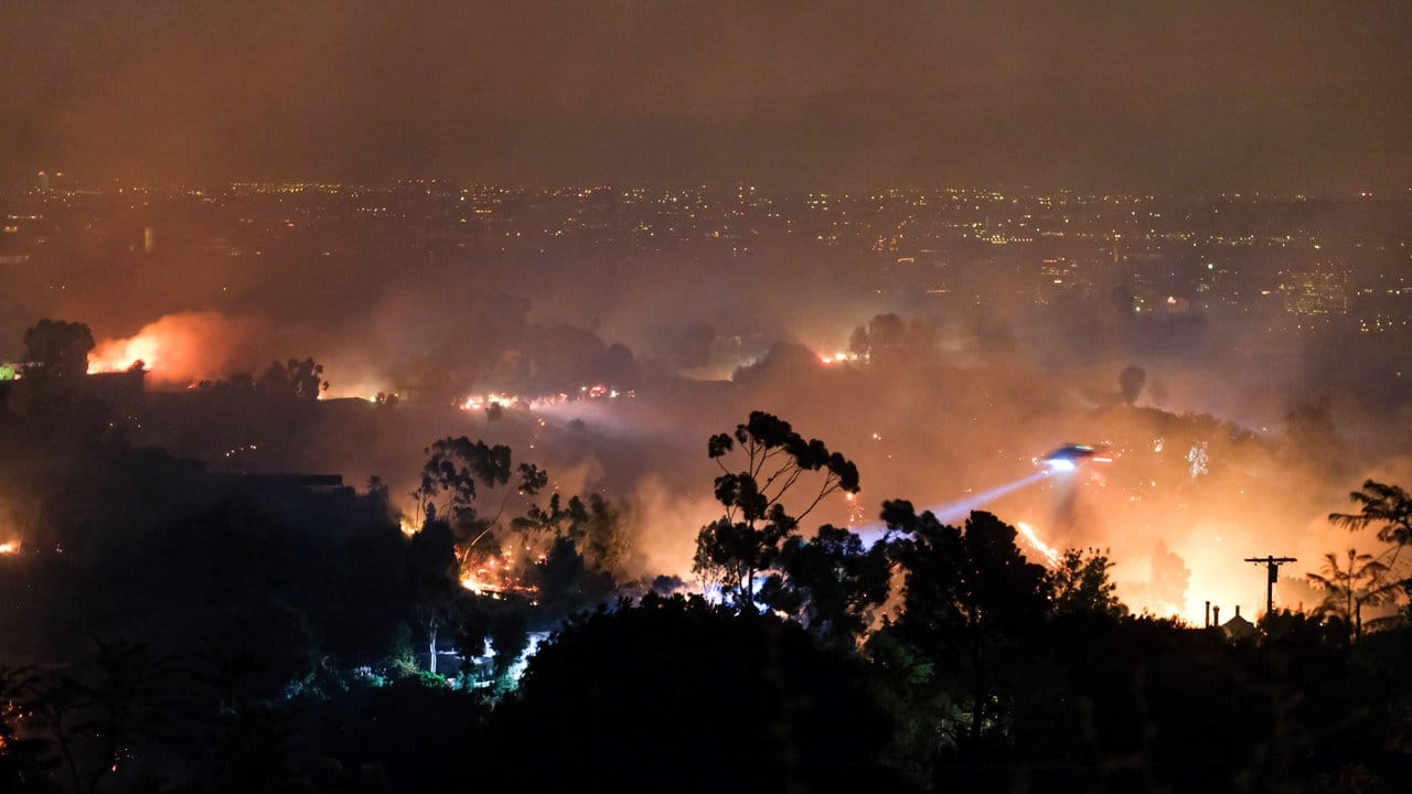 Ein Hubschrauber fliegt über einem Wohngebiet, das vom sogenannten "Getty"-Feuer betroffen ist.