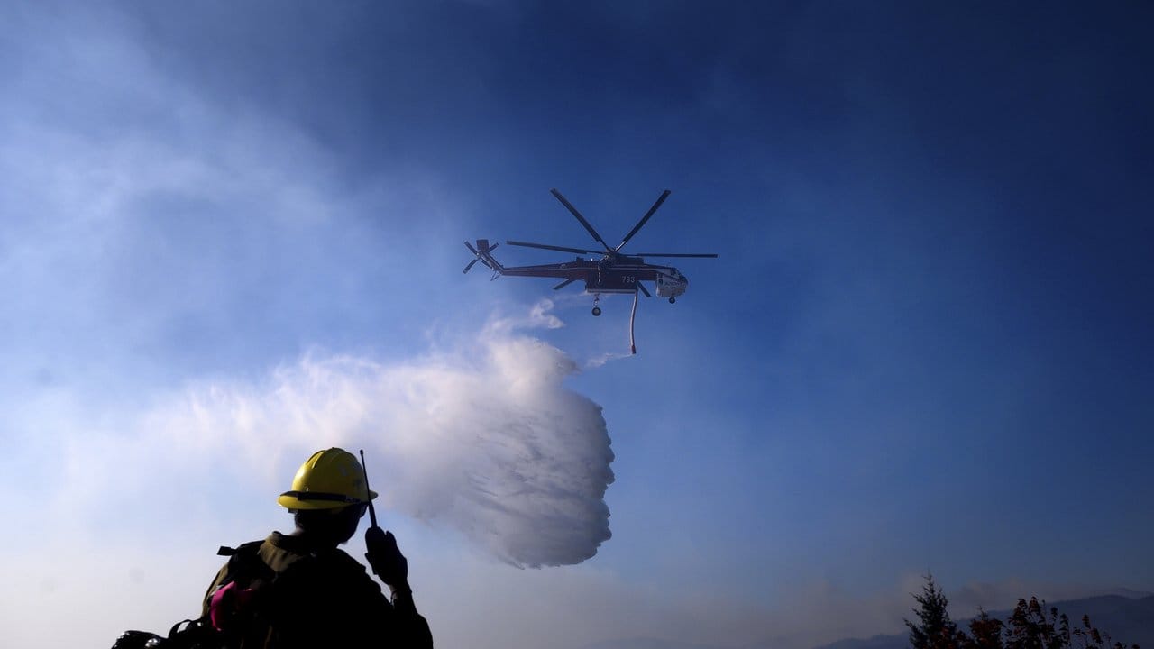 Ein Hubschrauber ist bei einem Waldbrand im Einsatz.