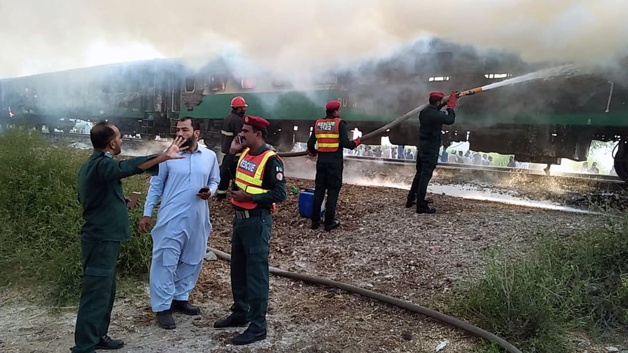 Rettungskräfte der Feuerwehr versuchen, das Feuer des Personenzuges zu löschen.