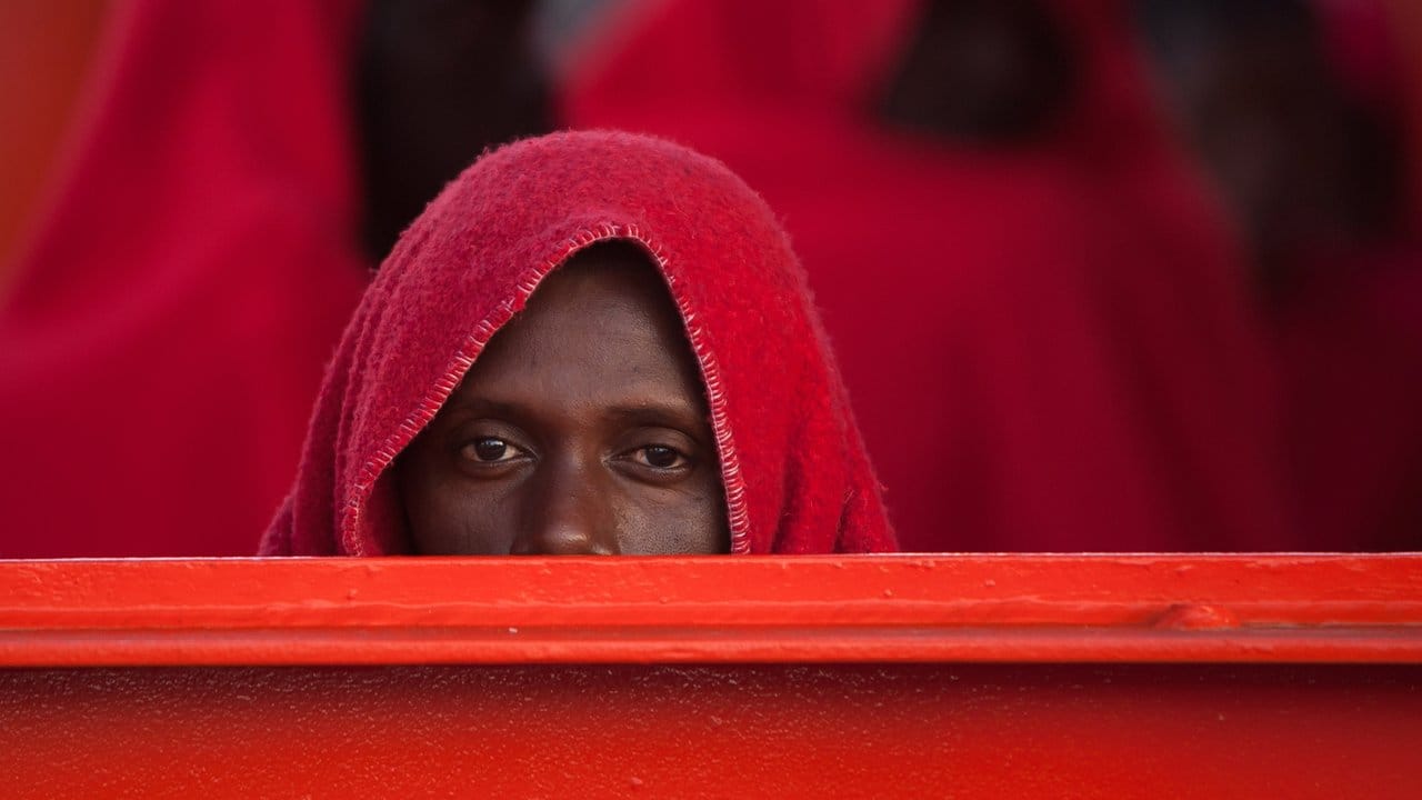 Und was kommt nun? Ein afrikanischer Migrant wartet in eine Decke gehüllt nach seiner Ankunft im Hafen von Malaga.